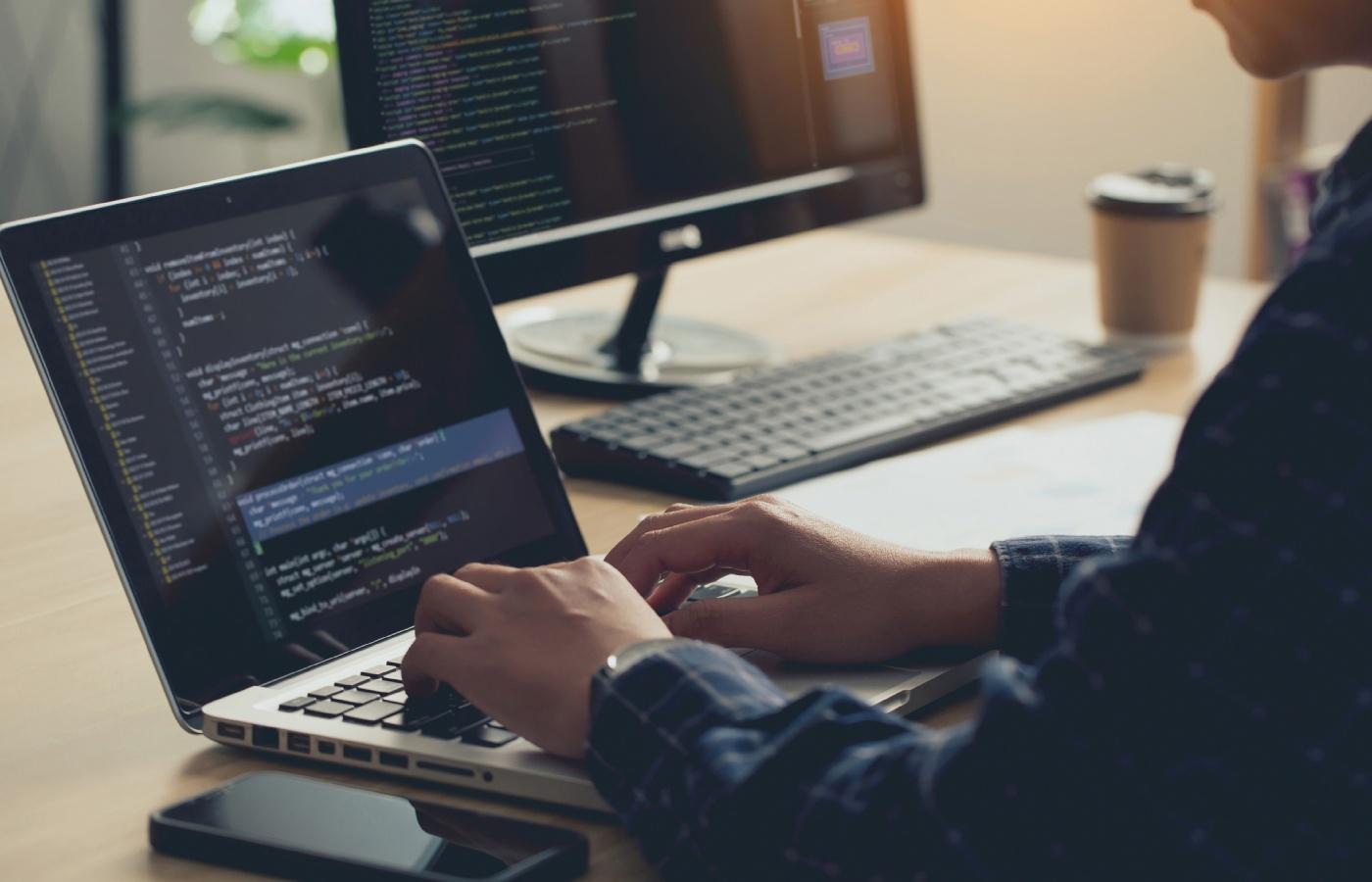 Developer working on source code in a modern workspace, illustrating version control practices like commits and branching.