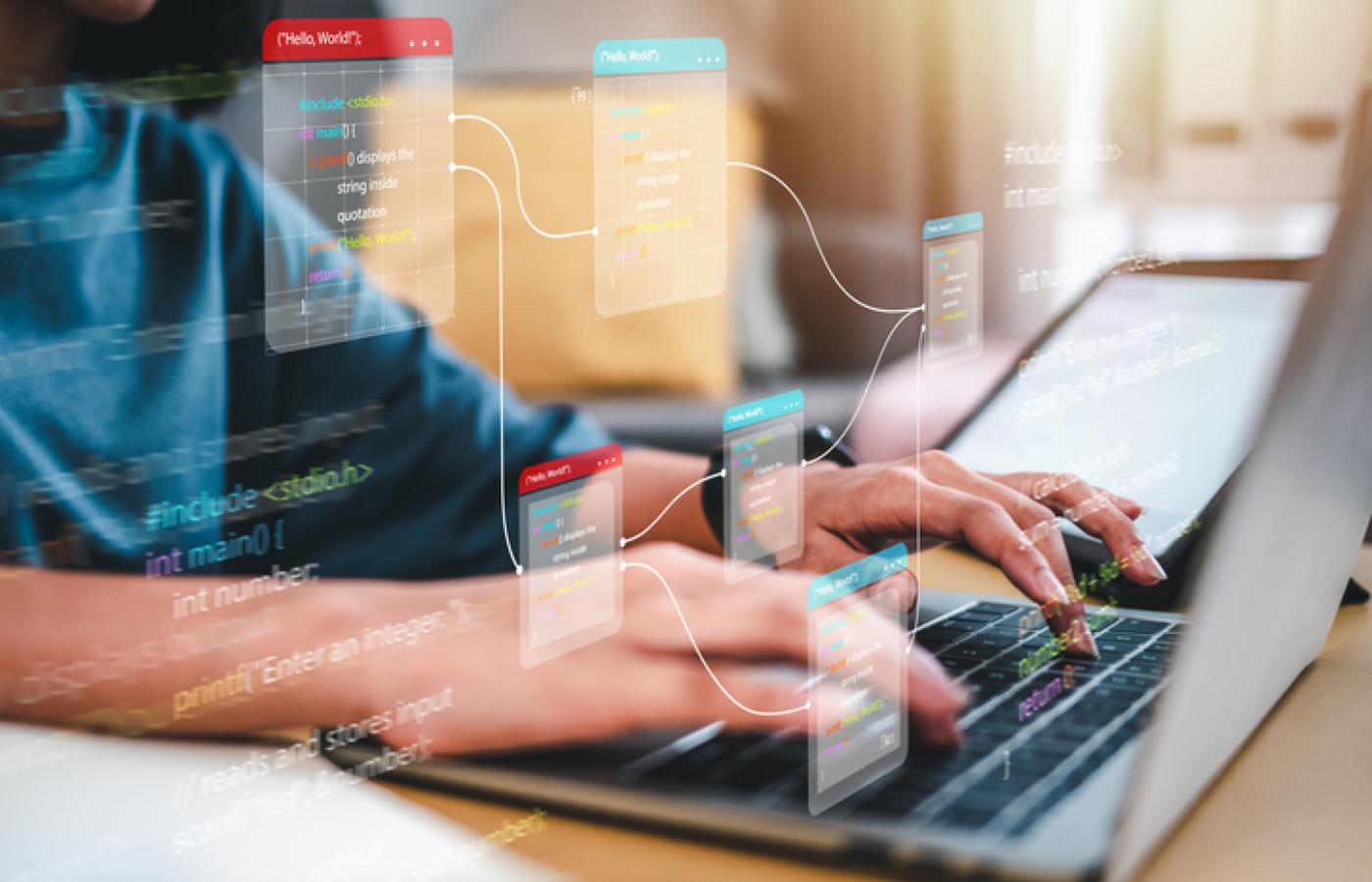 Close up image of hands typing on a laptop keyboard.