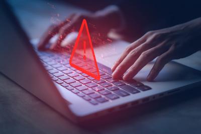 A red warning triangle hangs over a laptop. A website has been hacked.
